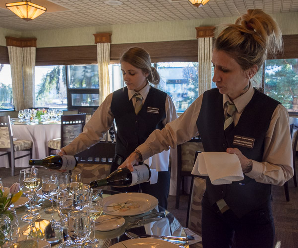 Students Alyssa L. Casler, of Barnesville, and Ashley R. Potrzebowski, of Williamsport, pour chardonnay to accompany the first course.