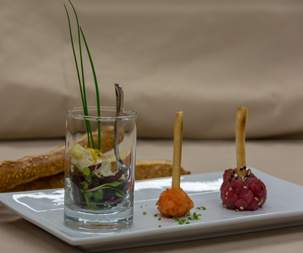 A trio of hors d’oeuvres: a lump crab flute with microgreens, spicy Louie and chives; and smoked salmon and ahi tuna lollipops.
