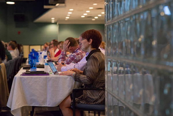 An attentive audience takes notes during the keynoter's remarks.