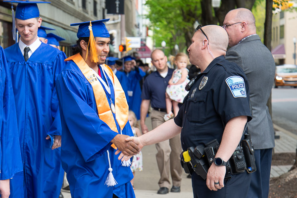 Three-time graduate Christopher J. Morrin shakes the hand of Penn College Police Officer Justin M. Hakes. Already the achiever of degrees in heating, ventilation and air conditioning technology and building automation technology, Morrin’s degree of the day was in electrical technology. 