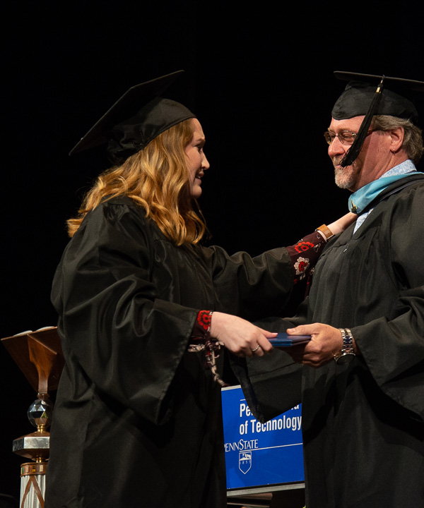 An emotional Madison H. Januchowski receives an emergency management technology diploma from her father, Jeffrey M., an assistant professor in automotive technology: Ford ASSET.