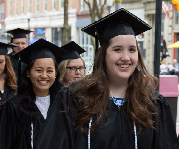 The smiles of graphic design graduates MinhThu H. Nguyen (left), of Montoursville, and Felicia R. Hartzler (right), of Dover, help to light the way to the ceremony.