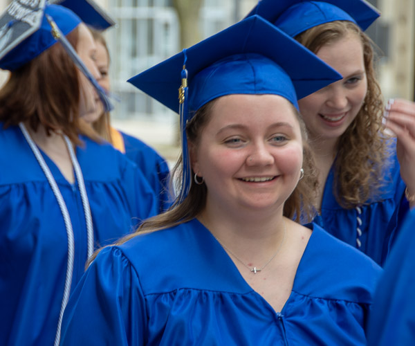 Smiles abound among early childhood education grad Taylor D. Lang, of Williamsport, and her classmates on the pre-commencement procession up West Fourth Street.