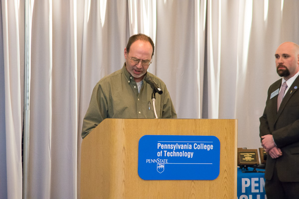 Last year's Adviser of the Year, the Penn College Motorsports Association's Christopher H. Van Stavoren, introduces the 2017-18 honoree. Beside him at the podium is Sal Vitko, assistant director of student activities for student organizations and orientation.