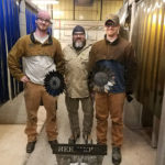 In the welding lab (from left), Sparkman, Nolan and Carlson display their towering, flowering creation ...