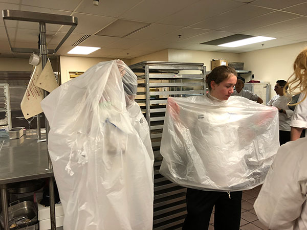 The hospitality students prove resourceful by transforming garbage bags into emergency ponchos. 