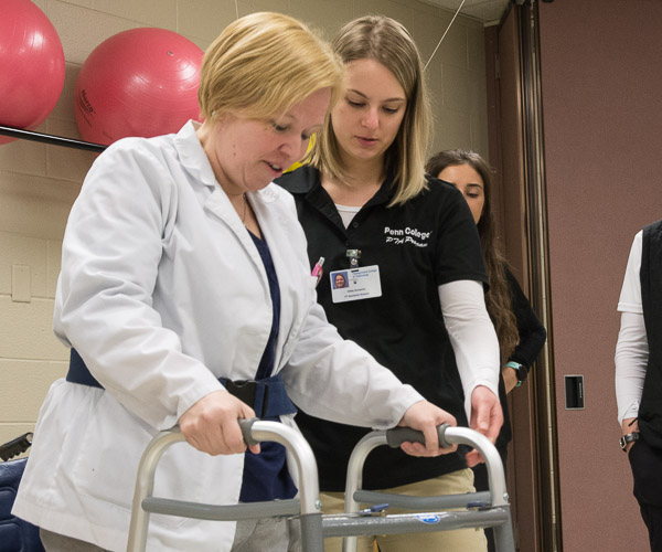 Physical therapist assistant student Emily C. Benjamin, of Fairport, N.Y., simulates a therapy session with “patient” Catherine A. Fisher, a physician assistant student from Elysburg. The simulated case escalated when the “patient” had a stroke during the session.