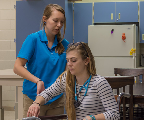 Occupational therapy assistant student Christine E. Jameson, of Chadds Ford, talks through means she would use to help a stroke patient, who has lost mobility in an arm, to do everyday tasks. Playing the role of the patient is physician assistant student Kurstyn T. Pfleegor, of Northumberland.