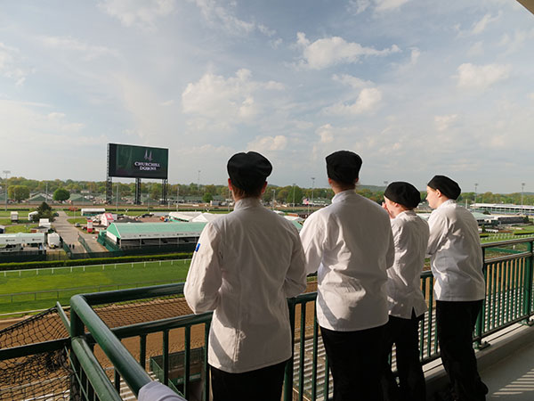 Students enjoy a momentary escape from their windowless kitchen to soak in Churchill Downs.