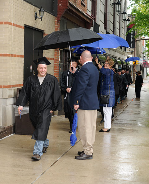 Helpful college employees provide a gauntlet of protection along West Fourth Street.