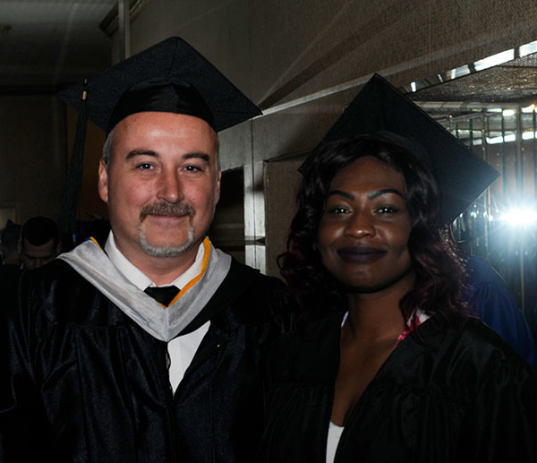 Roy H. Klinger, automotive restoration instructor, with Vanessa Mathurin, a restoration alumna who added a bachelor's in applied management on Saturday