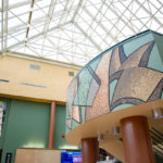 The mosaic art complements existing artwork and painted elements of the space.