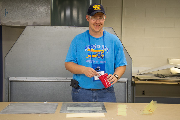 Decked out in an appropriate “Born to Fly” T-shirt, an Aviation Camp teen works with composite materials. 