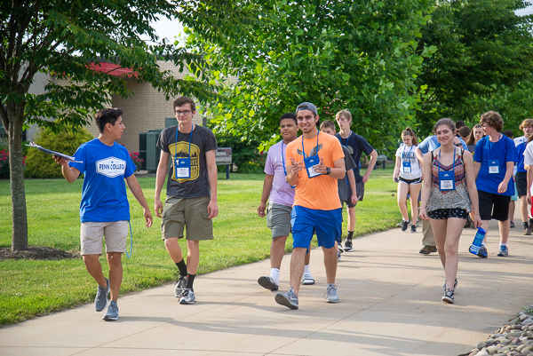 On their way to a scavenger hunt are these campers led by Joseph M. Morrin (far left), summer conference assistant and graphic design student. 