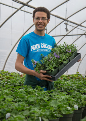 National “HortScholar” Aaron A. Sledge Jr., a May graduate in landscape/horticulture technology: plant production emphasis, welcomes Open House visitors to a Penn College greenhouse.