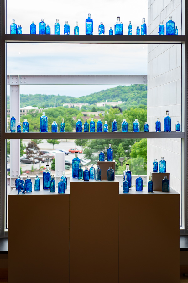 A stunning display in the gallery’s window highlights Ralph Wilson’s “Blues in a Bottle” project …