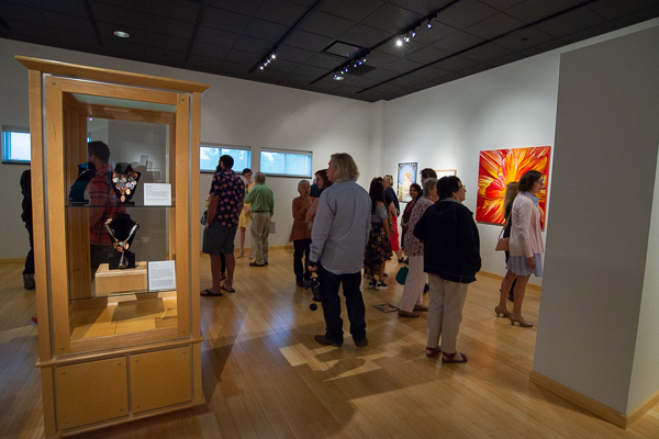 A corner of the gallery bustles with eager art patrons. 