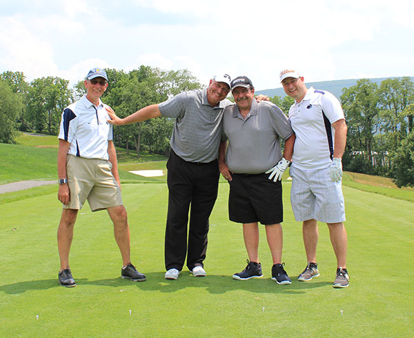 A playful pose by a group that includes Golf Classic Committee member John Confer (at arm's length) and co-chair Paul Rooney (second from right). 