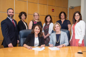 Representatives from Pennsylvania College of Technology and Milton Hershey School gather for the signing of an agreement formalizing a partnership supporting MHS graduates’ success at the college. Seated (from left) are Tanya Baynham, vice president of graduate programs for success at Milton Hershey School; and Carolyn R. Strickland, vice president for enrollment management and associate provost at Penn College. Standing (from left) are Dave Curry, director, career and technical education, Sheila Ciotti, manager, college and career preparation, and Keri Ambrocik higher education support specialist, all from MHS; and Melissa M. Stocum, academic skills specialist academic mentoring program, Tanya Berfield, manager of college transitions, and Kathleen V. McNaul, manager of academic services and international programs, all from Penn College.