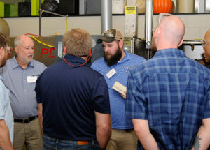 Workshop attendees get small-group attention from Jerry Ramsey (left), president and owner of Akro-Plastics, and Anthony P. Wagner, of Williamsport, a Penn College student and Plastics Innovation & Resource Center research assistant.