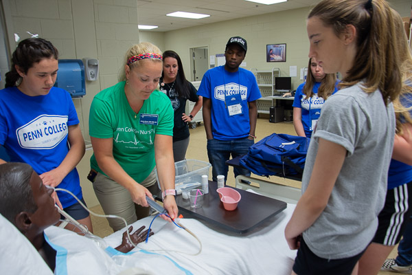 Jessica L. Bower, nursing simulation lab coordinator, walks campers through the insertion of a nasogastric tube in one of the nursing program’s three dozen manikins.