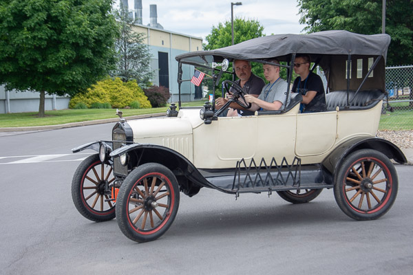 With guidance from Roy H. Klinger, instructor of collision repair, campers drive a Ford Model T around the parking lot.