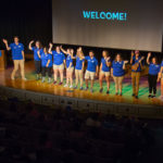 A welcoming wave from the Connections Links as they take the stage in the Klump Academic Center Auditorium. 
