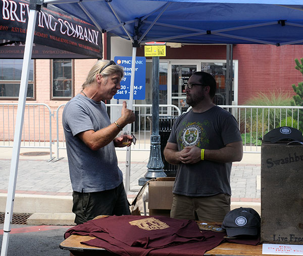 ... and stops by the swag-laden Swashbuckler Brewing Co. booth to talk shop with a Manheim-based colleague.
