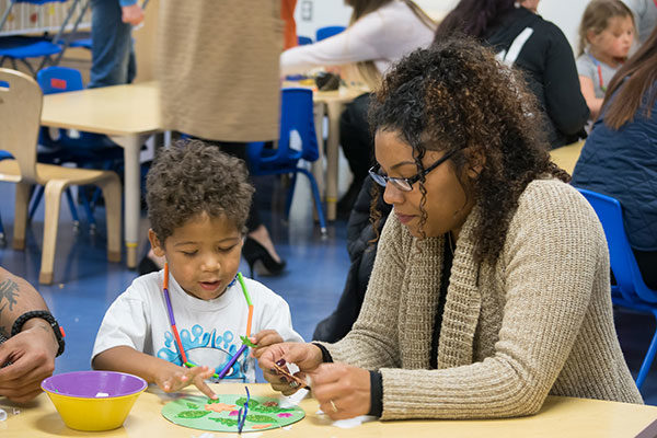 Pennsylvania College of Technology student Shaunice M. Douglas, of Williamsport, completes a craft with her son during a family event at the Children’s Learning Center, which provides on-campus child care for the children of Penn College students and employees while their parents attend class or work. Douglas is a pre-nursing student.