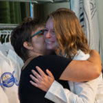 Hannah M. Frantz, of Hershey, accepts a hug from Christine Frantz, who presented her pin. White coats were given by instructor Larissa D. Whitney, and each student chose an individual to attach his or her pin.