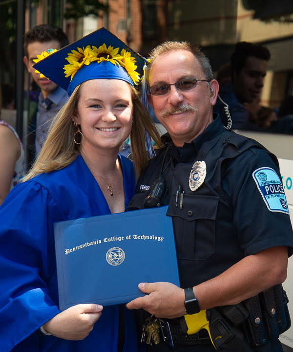 Penn College Police Officer Charles E. O’Brien Jr. joins the celebration with family friend Janelle R. Wheeland, of Williamsport, who graduated in occupational therapy assistant. 
