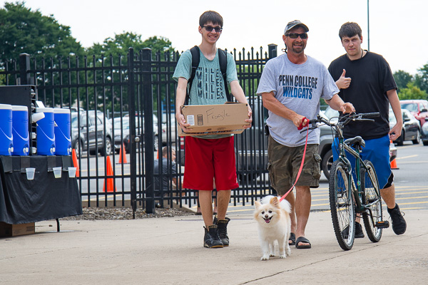 Izzy leads the way! Anthony Ionata III (with thumbs-up), receives move-in assistance from his brother, father and pup, Izzy. Ionata, of Ambler, is majoring in industrial design.