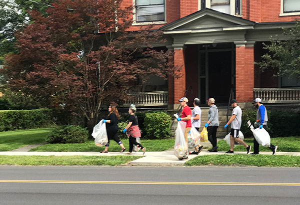 Bags in hand, a group enhances the appearance of an off-campus thoroughfare.