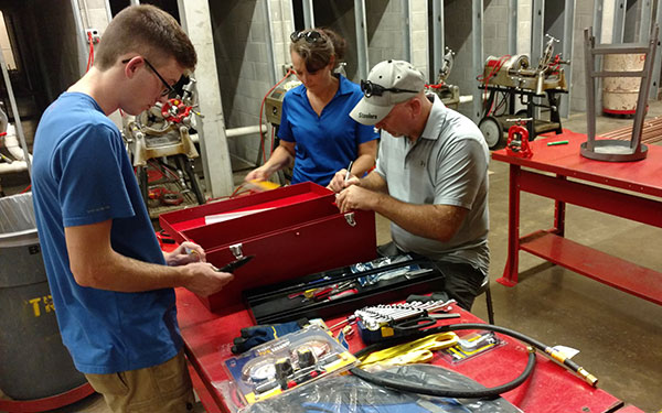 Sam J. Ulery, a first-year heating, ventilation and air conditioning technology student from Mount Pleasant, drops off his toolbox in the Carl Building Technologies Center – joined by parents Kim and Denny.