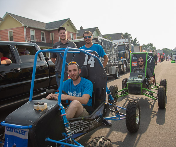Members of the Baja team returned to campus early to test their off-road vehicles and rev them up along the parade route. Seated in the No. 14 car is Daniel M. Gerard, of Doylestown. The remainder of the group, from left, is made up of Christopher M. Schweikert, of Jamison; Trevor M. Clouser, of Millmont; and Jonathan R. Sutcliffe, of Orangeville.