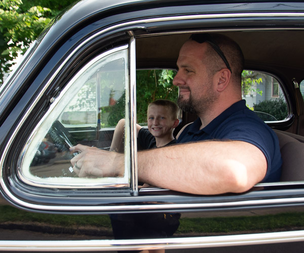 Automotive restoration technology student Erik W. Weigle, accompanied by his 12-year-old son, drives a 1939 Buick Roadmaster, which shares its birth year with Little League Baseball.