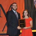 President Jordan D. Suter accepts a Chapter Excellence Award from Jackie Hackett, assistant executive director for undergraduate engagement, Phi Mu Delta national fraternity.