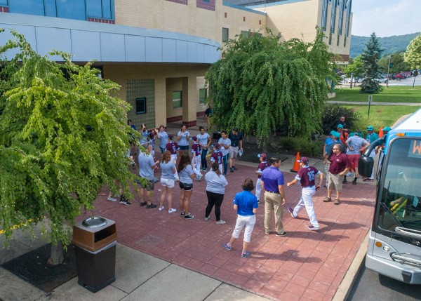 Student volunteers form a reception line outside the Bush Campus Center, as Public Relations & Marketing's Tina M. Miller and Tom Speicher (foreground) match each arriving team with its assigned picnic partner.