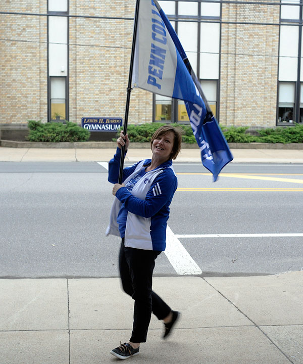 Noelle B. Bloom, assistant director of dining services, greets early risers with a friendly wave of the flag. 