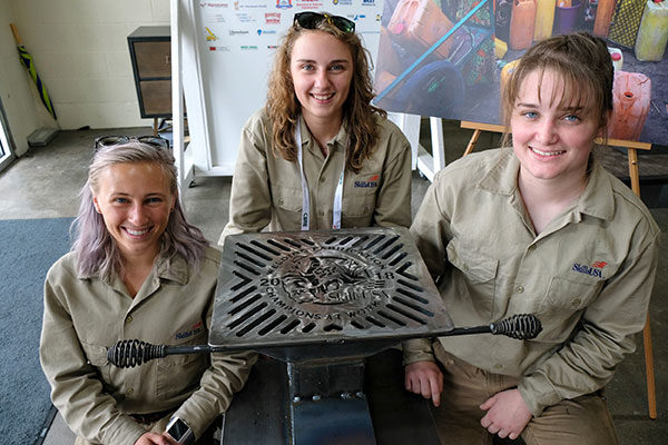 The all-female team from Penn College that participated in a welding fabrication competition at the SkillsUSA National Championships, shows the rocket stove they built during the event. The stove will be donated to a family in the developing world by WaterStep. From left are Joelle E. Perelli, of Bath; Natalie J. Rhoades, of Weedville; and Erin M. Beaver, of Winfield. 