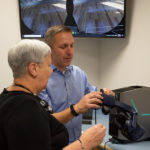 Jim R. Dougherty III, assistant director of classroom technology and A/V services, assists the president with the VR headset. 
