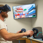 Industrial design student Tyler M. Schmill laughs heartily while slashing through Fruit Ninja VR.