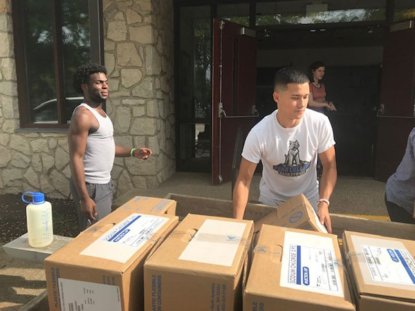 Unloading streetwise at the church are a pair of Penn College basketball players: Obens Luxama (left) and Antonio 