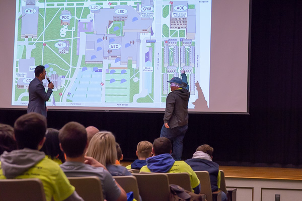 Jabbour receives assistance from a student – who jumped on stage to help – in pointing out the location of the welcome session on the college map (when orienting the guests to campus).