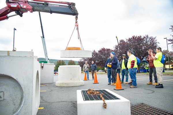 A student remotely controls the crane lifting a heavy piece of concrete in a challenging activity provided by Deihl Vault and Precast Inc., Orangeville.