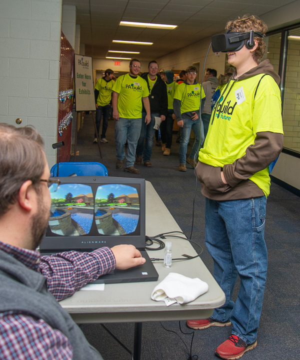 The virtual reality of landscape technology engages a guest in a hallway of the BTC (aided by Justin W. Beishline, assistant dean for transportation and natural resources technologies, in foreground). 