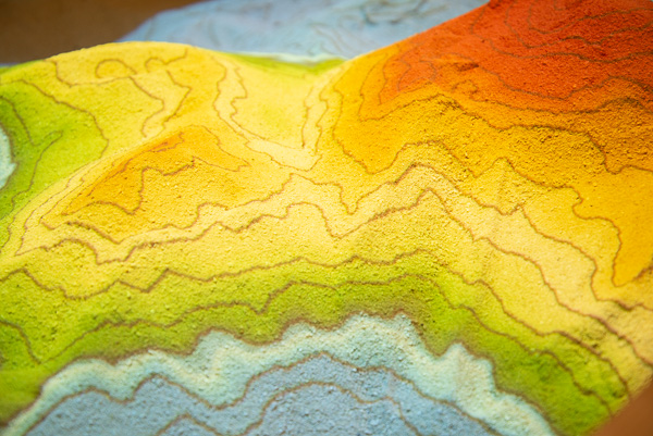 The augmented reality sandbox offers a colorful complement to the autumnal day. Incorporating a 3D camera, sensor, projector and computer, the unit reveals virtual topographical contour lines, an elevation color map and simulated water on sand. 
