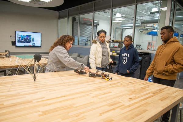 A family from Berwick explores the Dr. Welch Workshop – A Makerspace at Penn College and views “BattleBots” with Roberta Schwenk, makerspace assistant and a 1994 building construction technology graduate. 