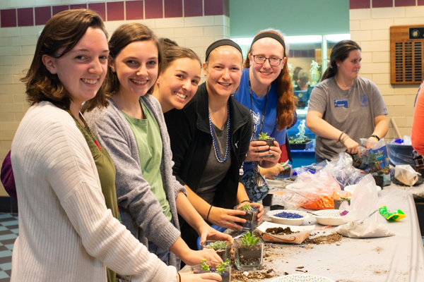 Judging from the smiles, this green-thumb exercise involves no growing pains whatsoever! From left are Sydney M. Camut, Shippensburg, engineering CAD technology, and sister Shaylan; Autumn G. McCrum, Dallas, baking and pastry arts; Marcie M. Harman, Nescopeck, architectural technology; and Ashley J. Hoffer, Manheim, baking and pastry arts. (The Camuts' father, Steven, graduated in 1990 with a degree in electrical occupations.)