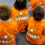 T-shirts, brightly bragging of the center's four-star accreditation, are sported by the enthralled library visitors.